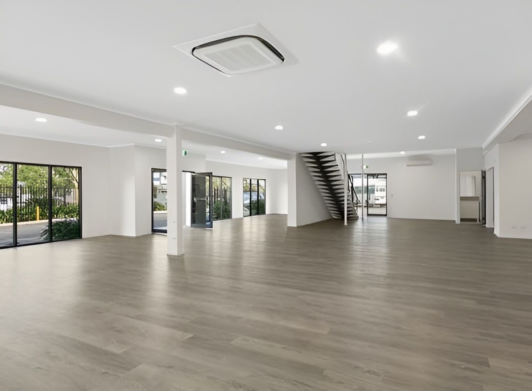 Empty Commercial Space With Gray Flooring, White Walls, and Large Windows — JGD Constructions in Atherton, QLD