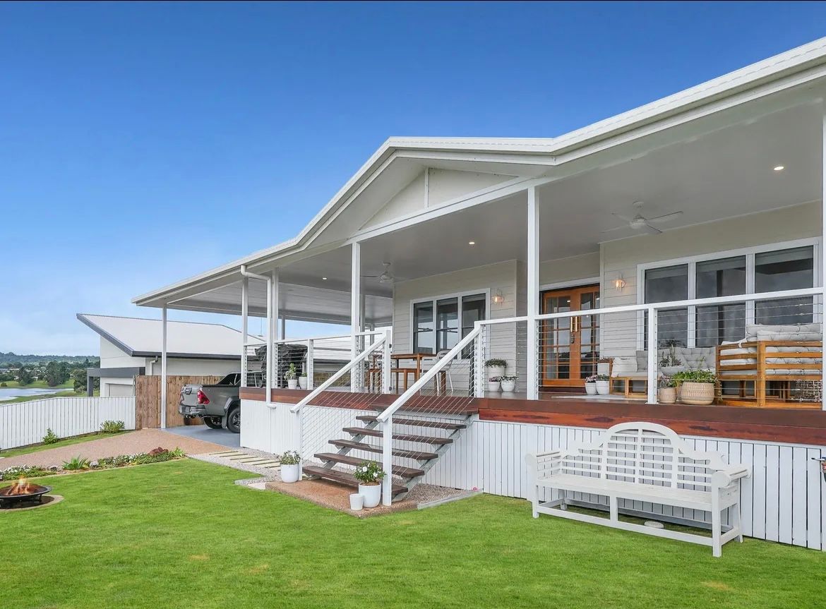 White House With Wraparound Porch And Steps Leading To The Front Door, Green Lawn, Blue Sky — JGD Constructions in Atherton, QLD