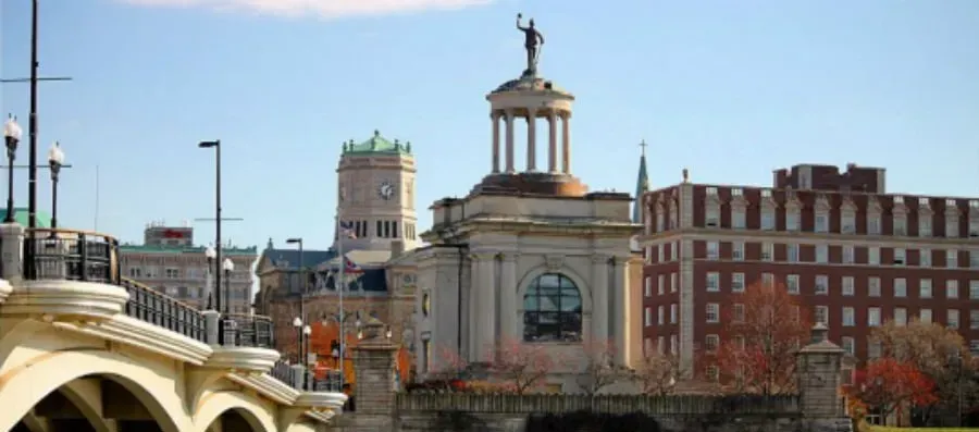 There is a bridge in the foreground and a large building in the background.