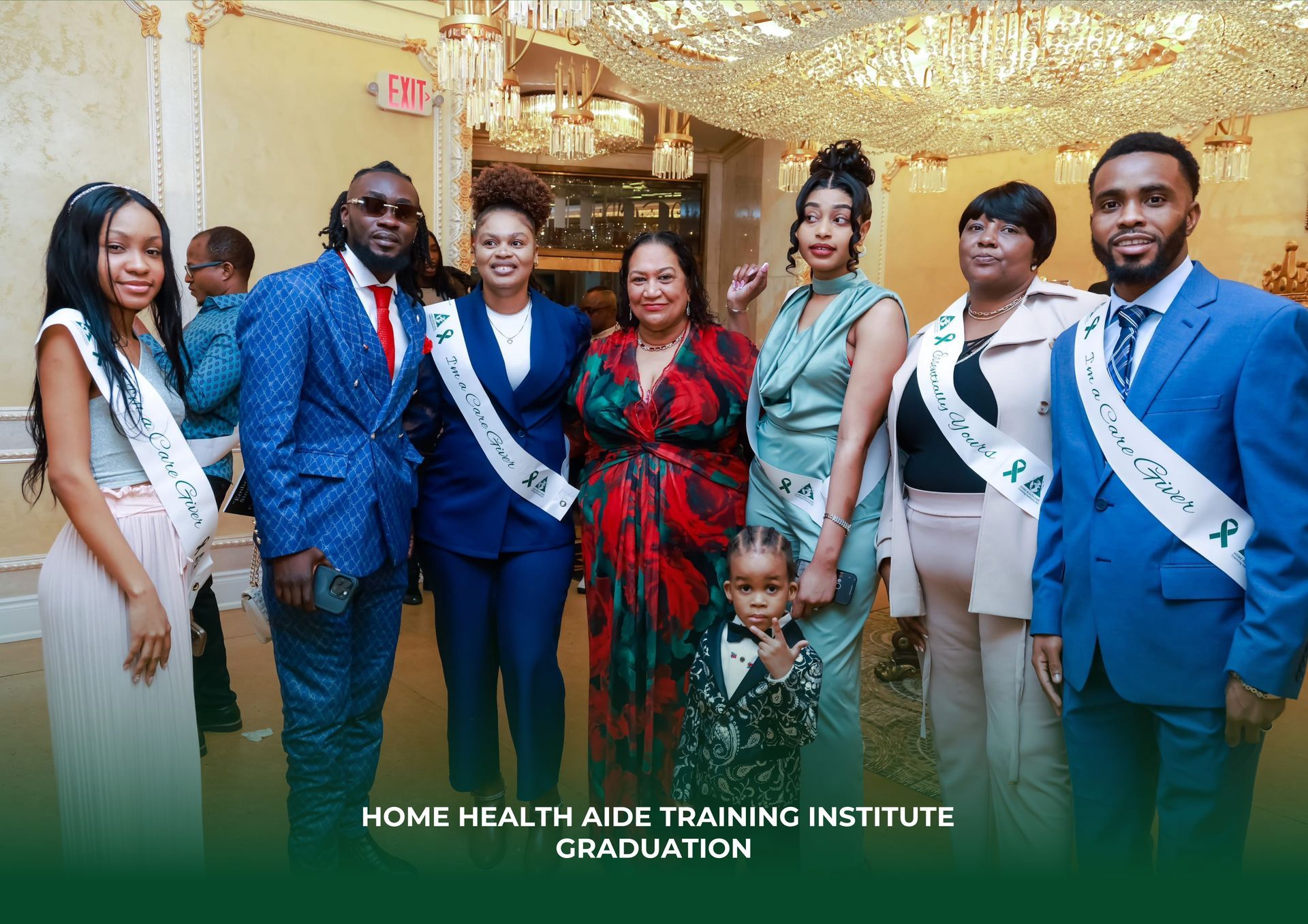 A group of people wearing sashes pose for a photo at a Home Health Aide Training Institute graduation ceremony.