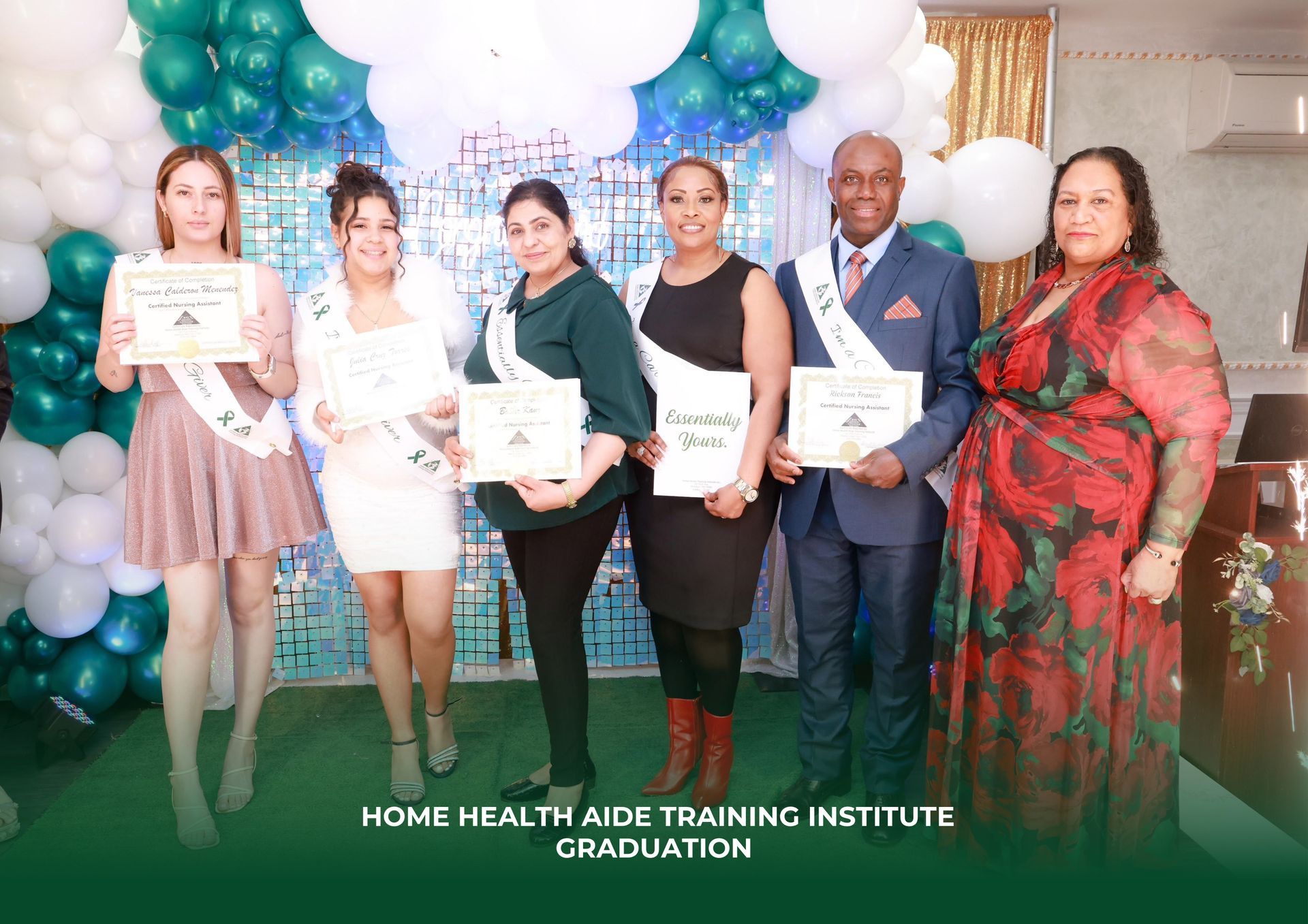 Graduates and staff standing in front of a balloon arch at a Home Health Aide Training Institute ceremony.