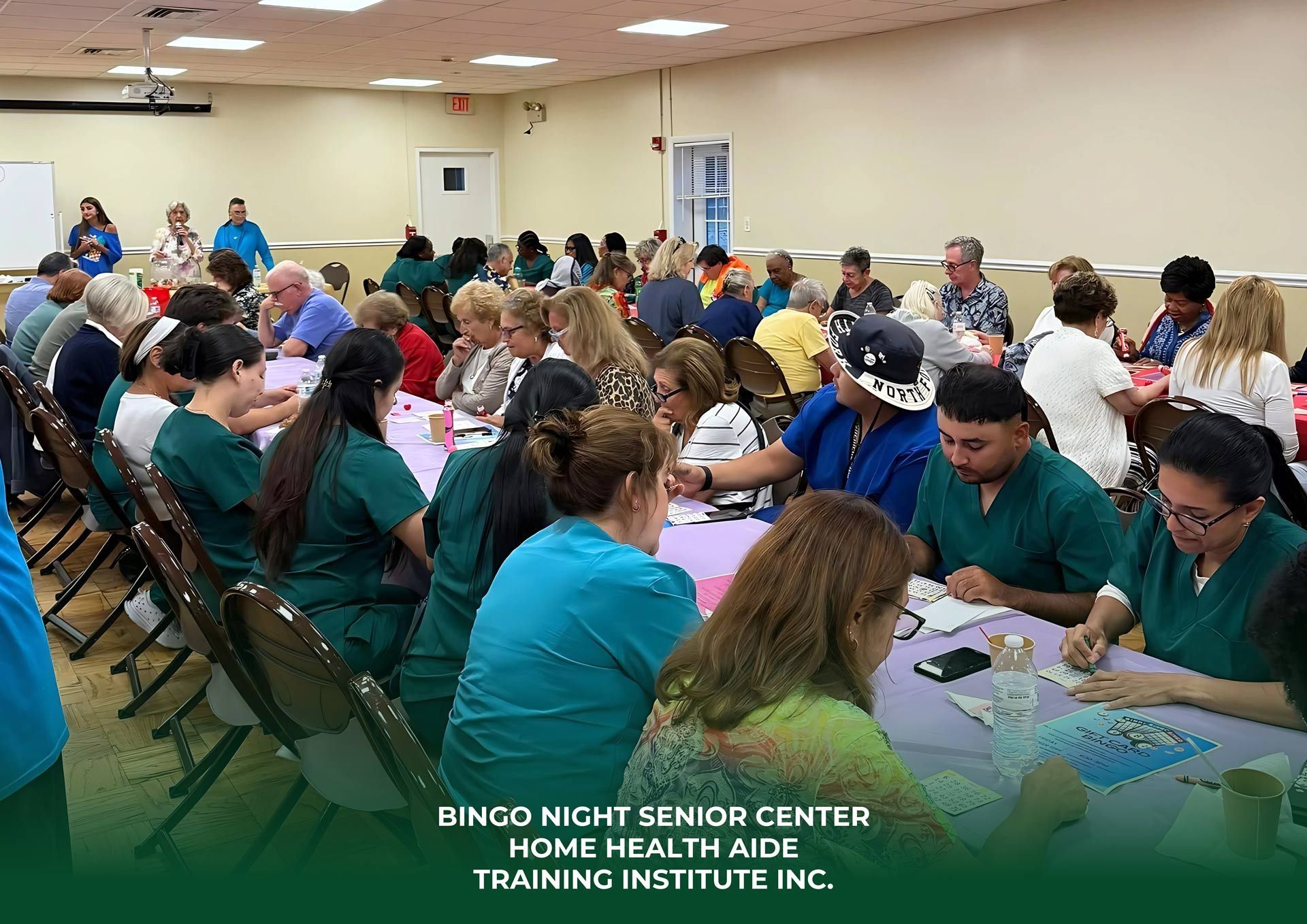 People in scrubs participate in a bingo night at the Home Health Aide Training Institute, seated at tables with cards.