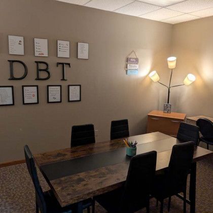 A therapy room with a long table, chairs, and 