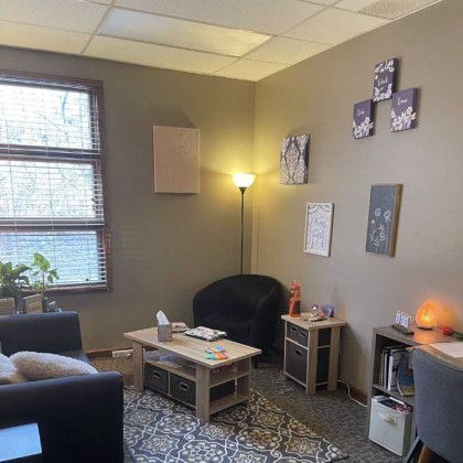 Cozy office with a couch, armchair, small table, and decor.