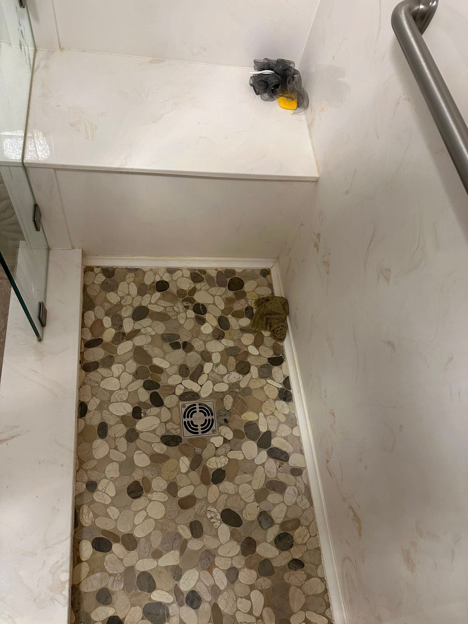 Narrow tiled stairwell with white walls and a small dark object near the top ledge