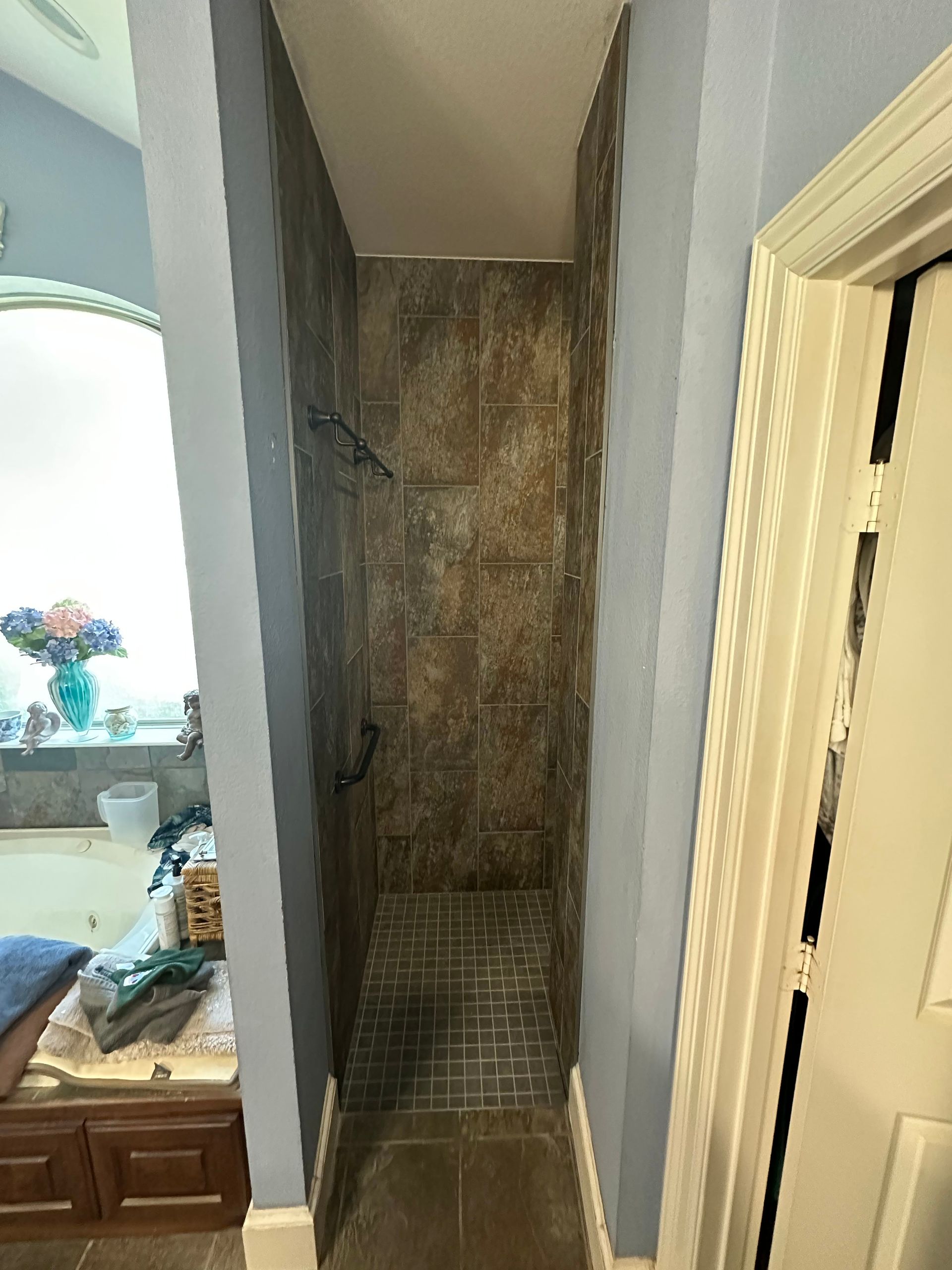 Narrow stairwell with worn walls and a small tiled landing between two doorways.