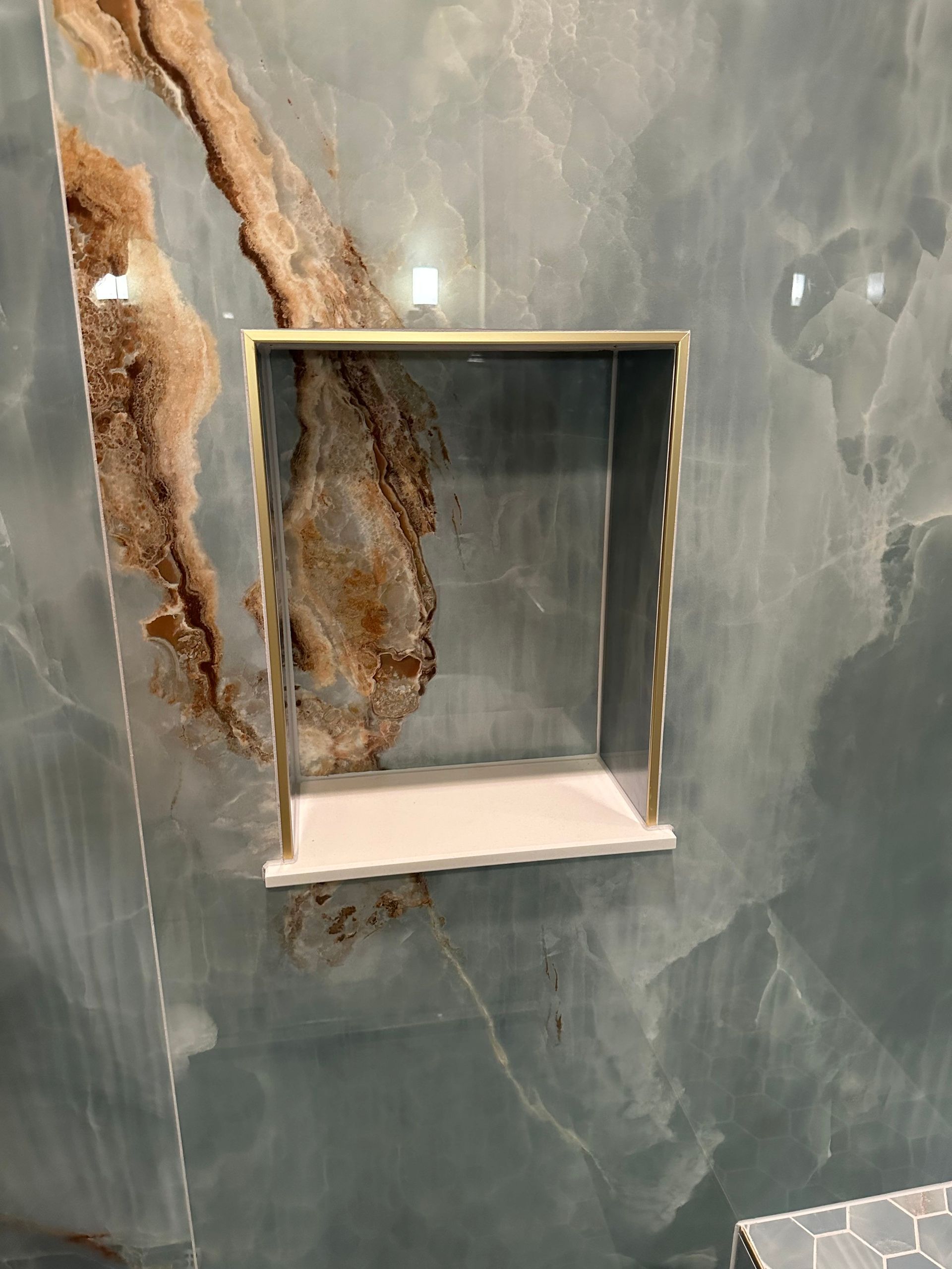 Marble wall with a recessed square niche and visible brown veining or damage on the left side