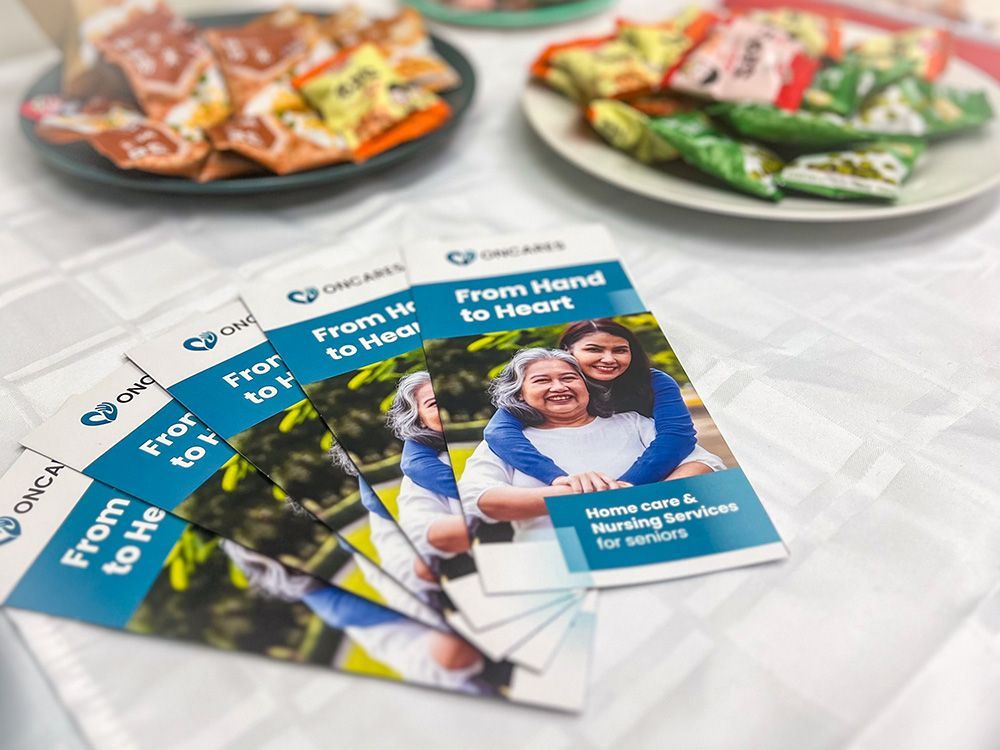 Brochures for senior home care services next to plates of snacks.