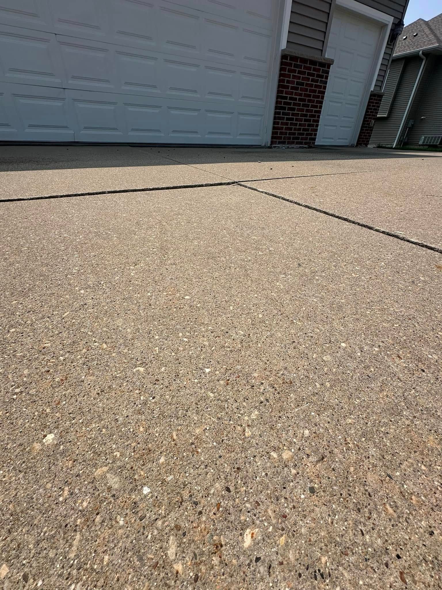 Driveway with a textured surface, leading to garage doors.