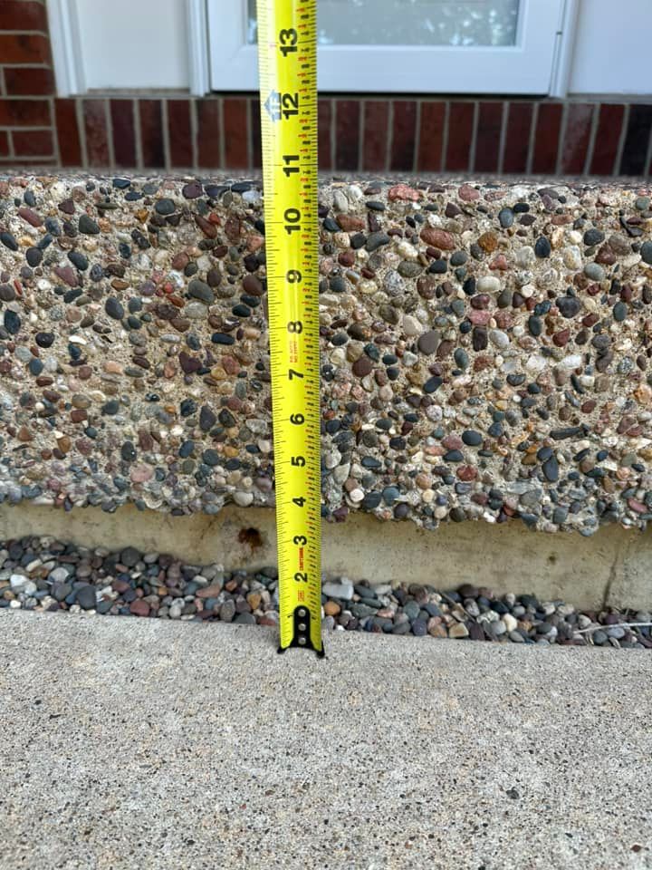 Yellow tape measure measuring a concrete step.