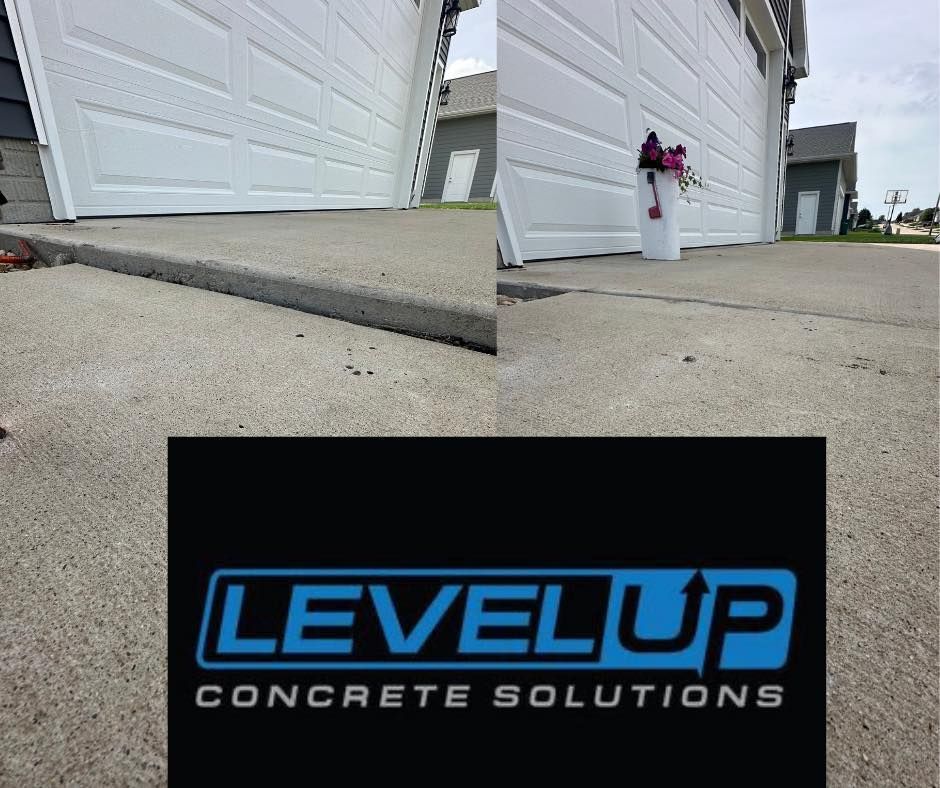 Concrete driveway and garage with Level Up Concrete Solutions logo.