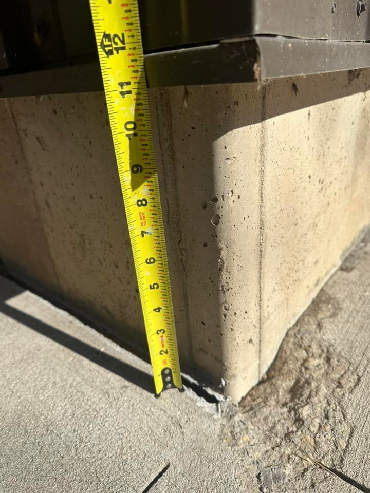 Yellow tape measure against a concrete ledge, showing a height of approximately 3 inches.