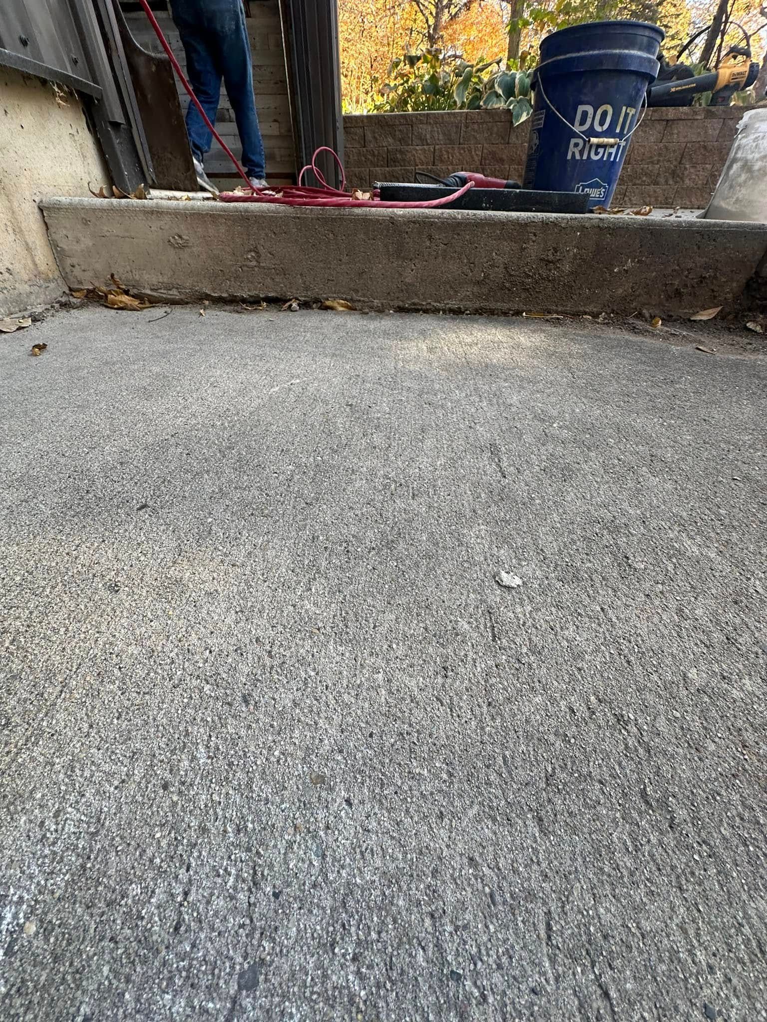 Concrete steps with a blue bucket and red hose.