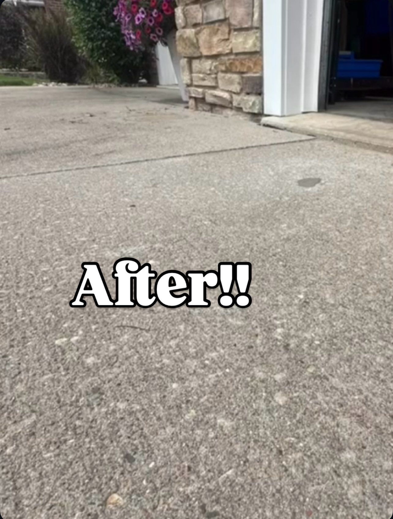 Gray concrete driveway next to a brick building; the word 