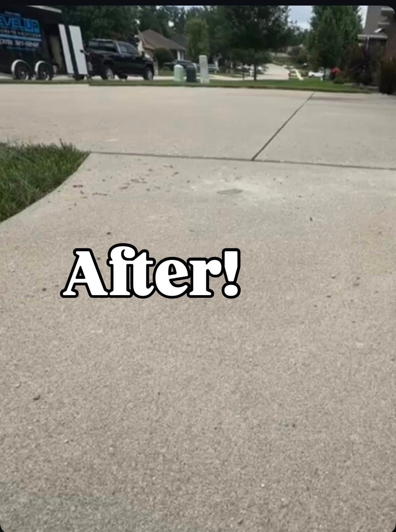 Concrete driveway after cleaning with truck and trailer in the background. 