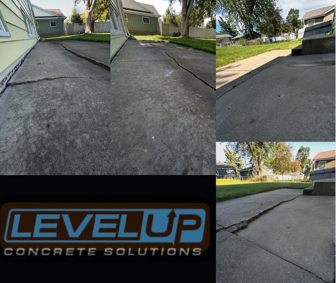 Cracked concrete driveway with LEVEL UP Concrete Solutions logo.
