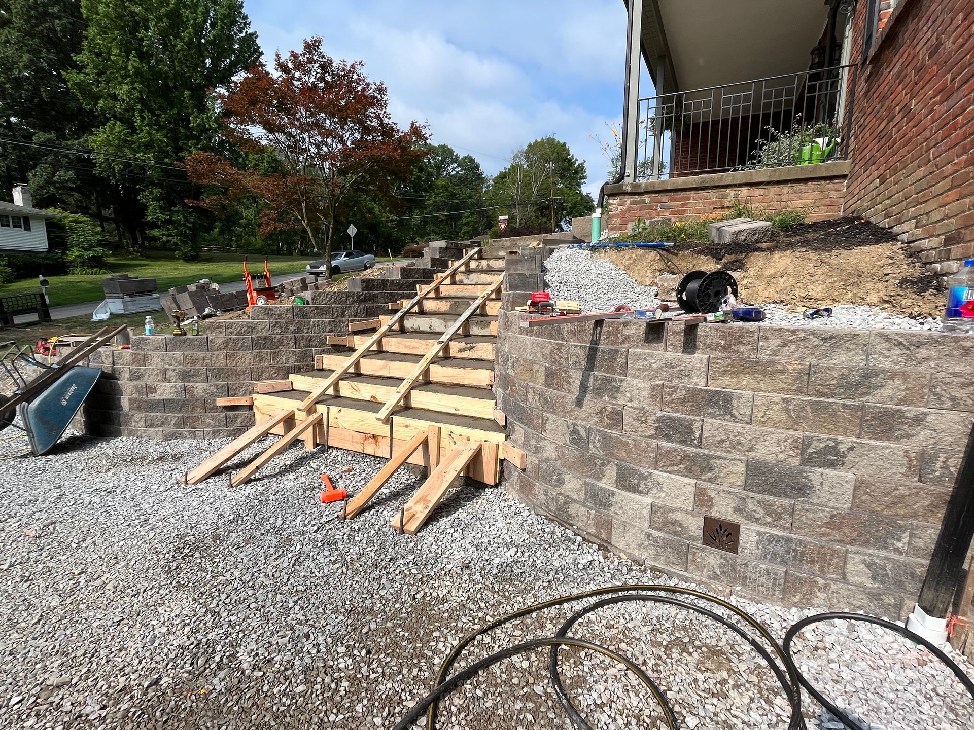 A brick wall is being built in front of a house.