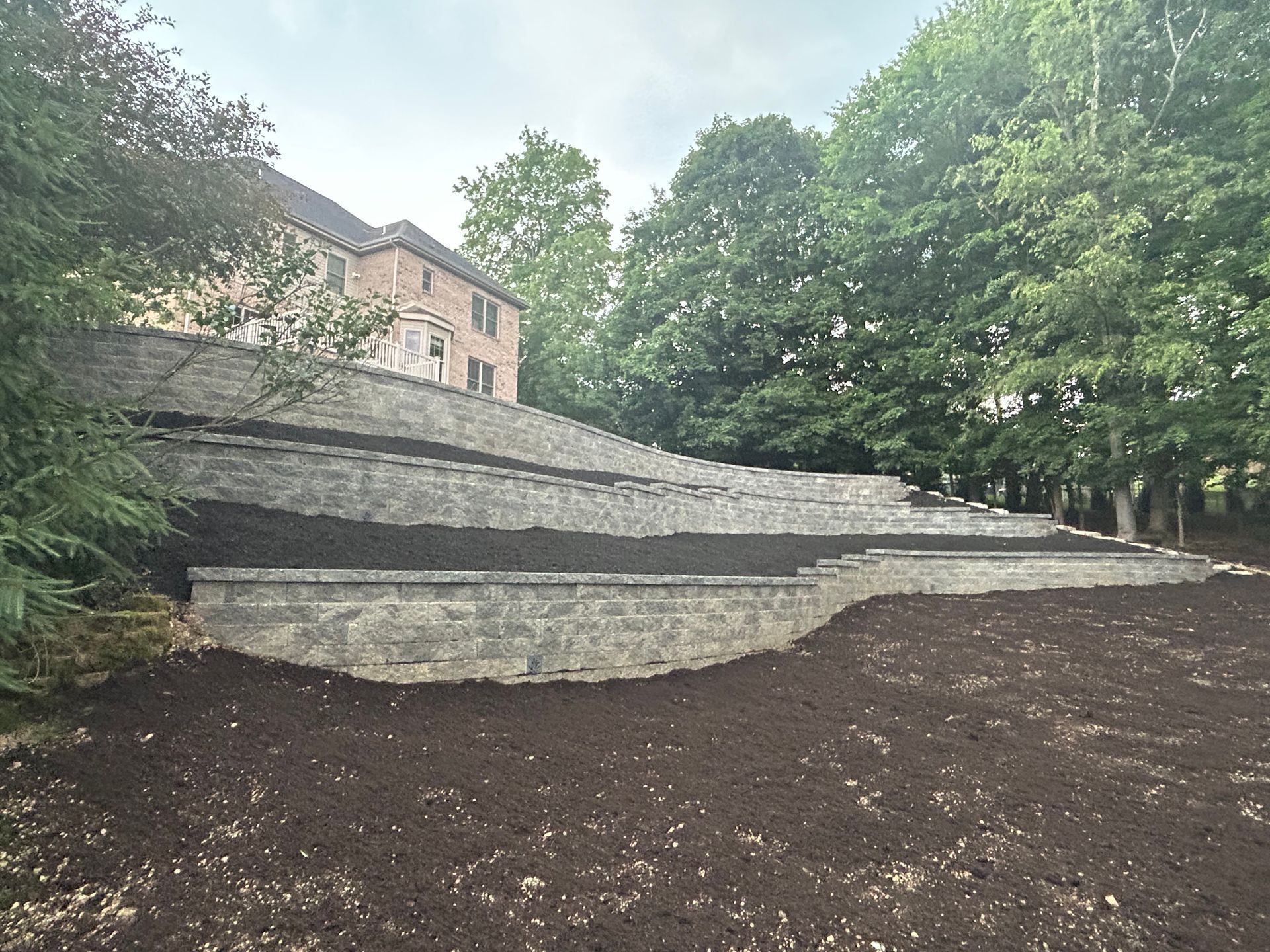 A brick wall with stairs leading up to a house.