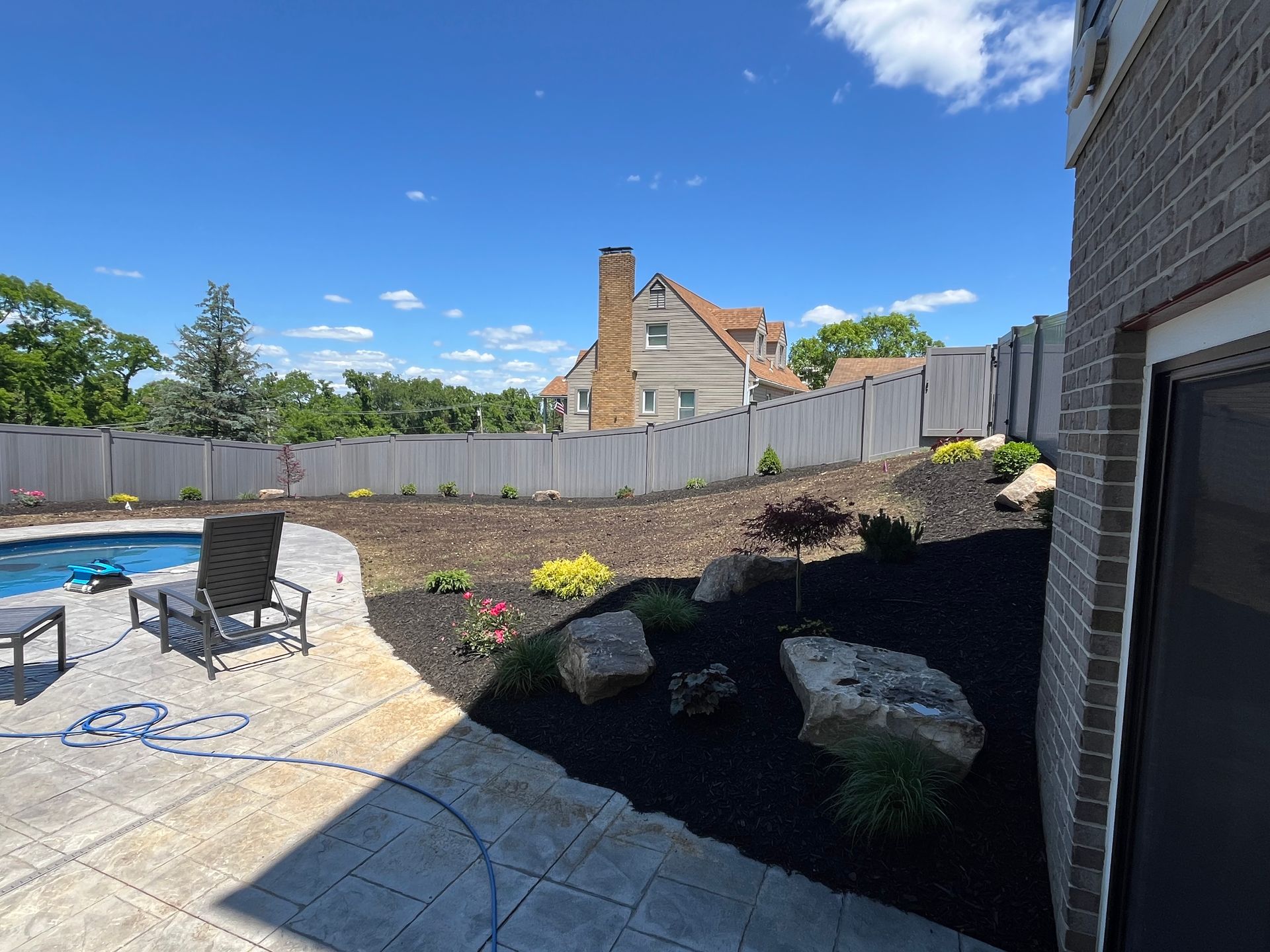 A backyard with a fence and a swimming pool