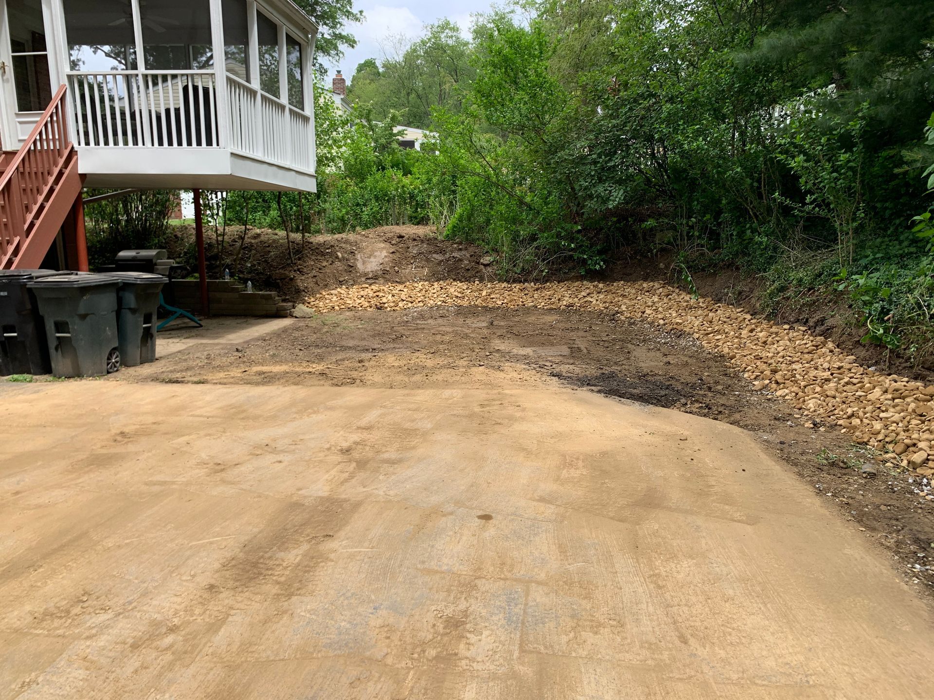 A dirt road leading to a house with a screened in porch.