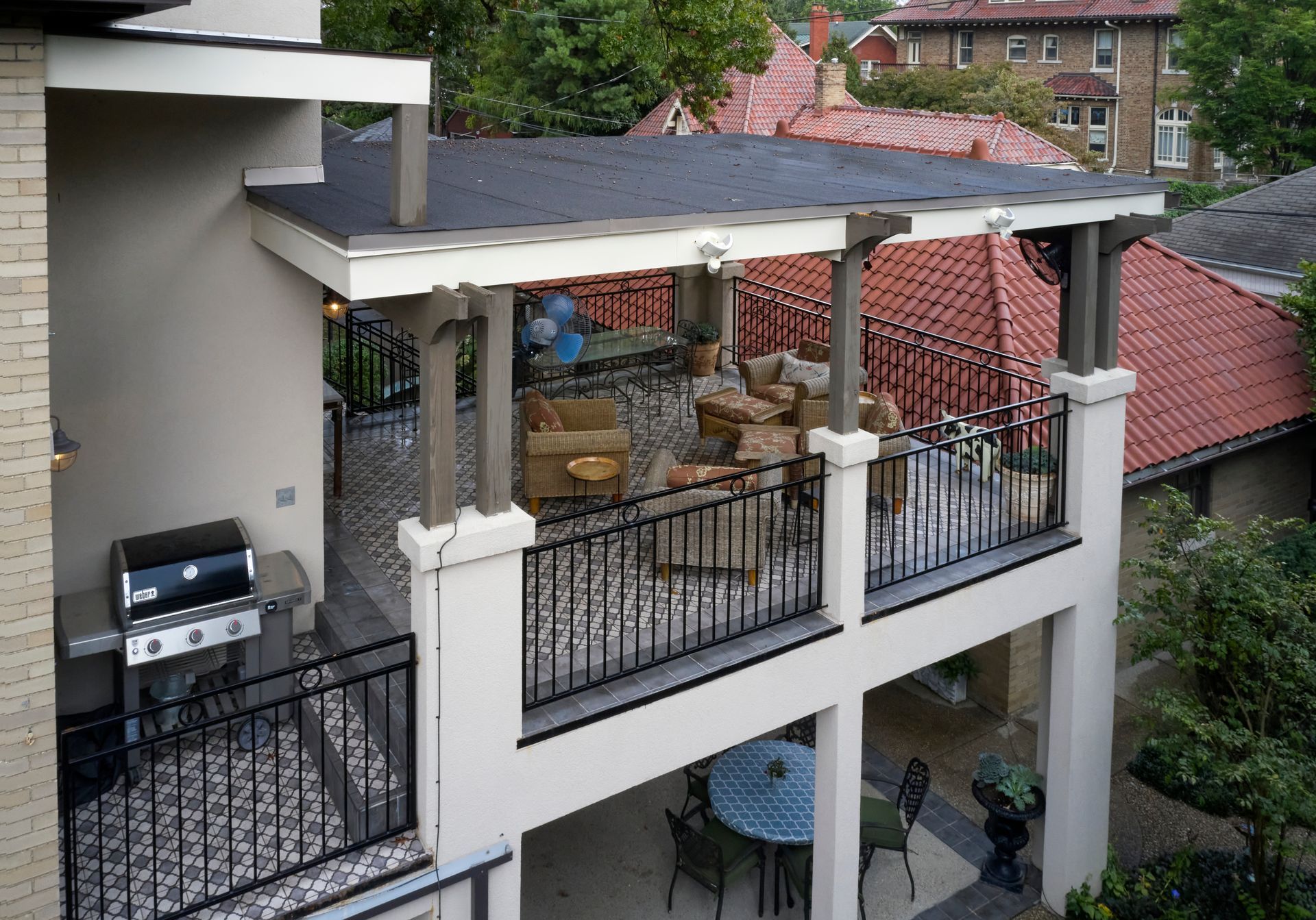 An aerial view of a balcony with a grill and chairs