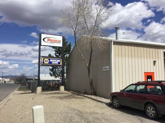 A car is parked in front of a building with a sign that says napa