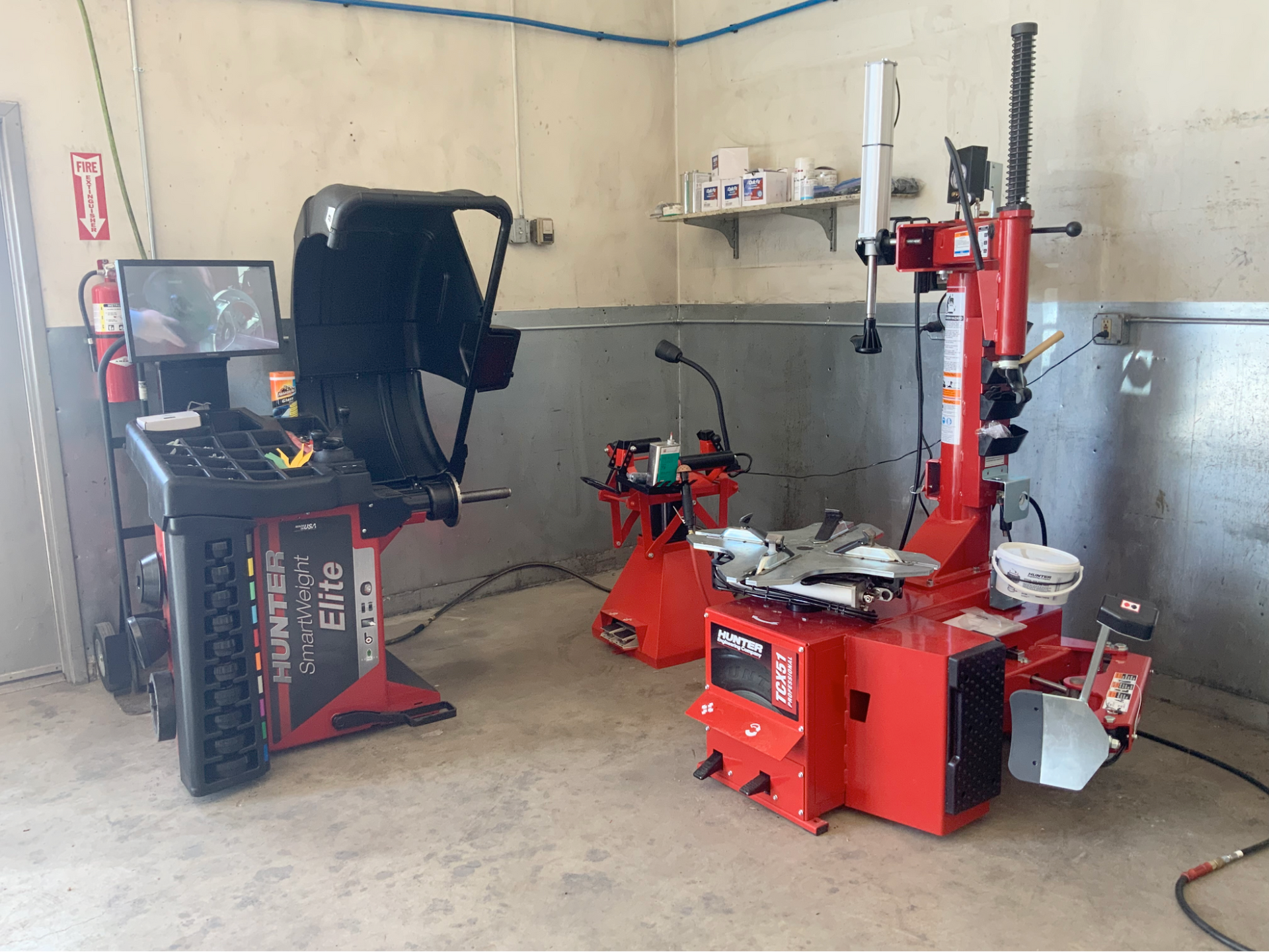 A tire balancing machine and a tire changer are in a garage.