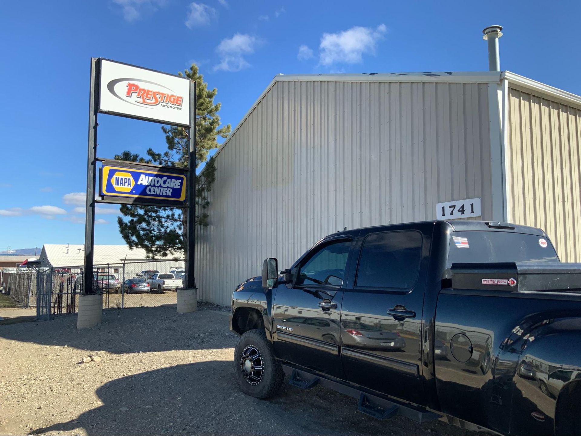 A black truck is parked in front of a building.