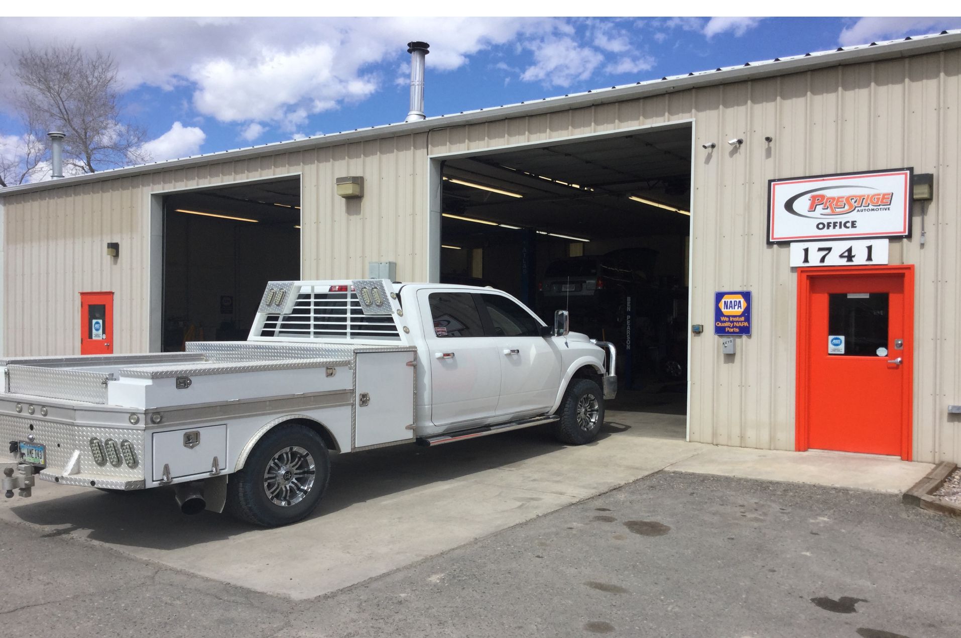 A white truck is parked in front of a building.