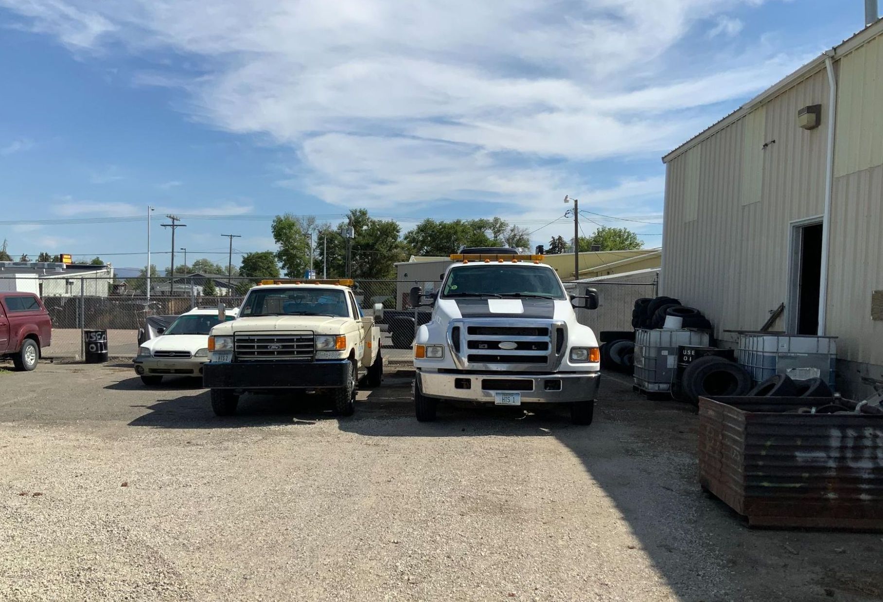 A row of tow trucks are parked in front of a building.