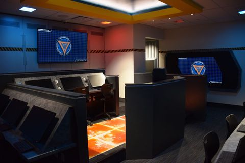 A room with a lot of monitors on the wall