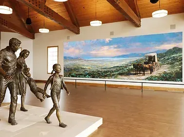 A room with a statue of a family and a painting on the wall.