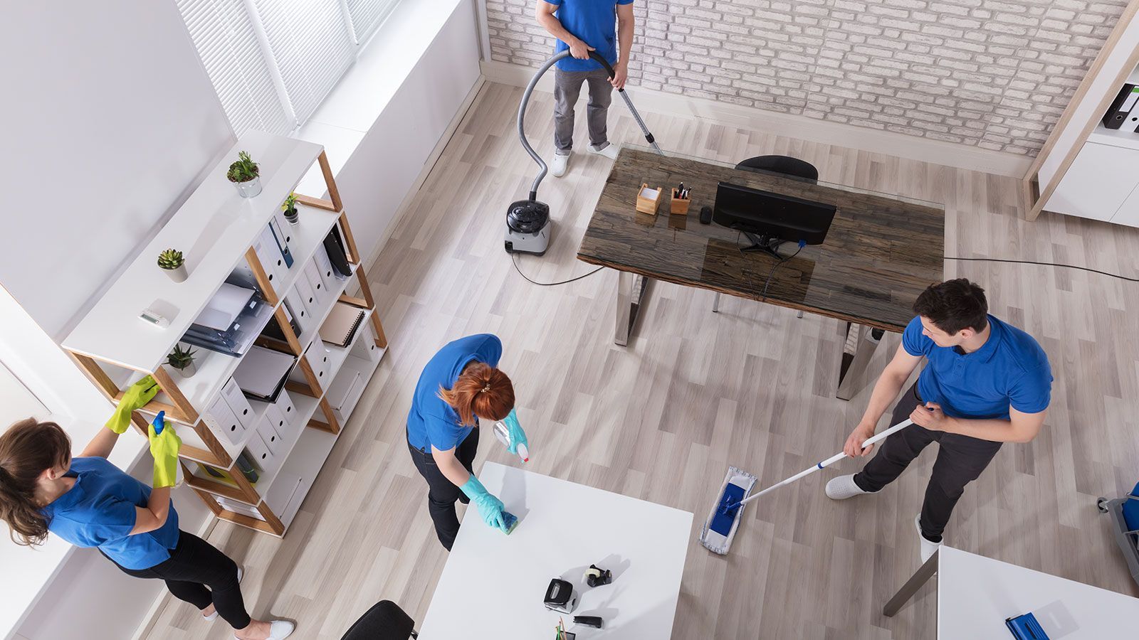 A group of people are cleaning a room in an office.