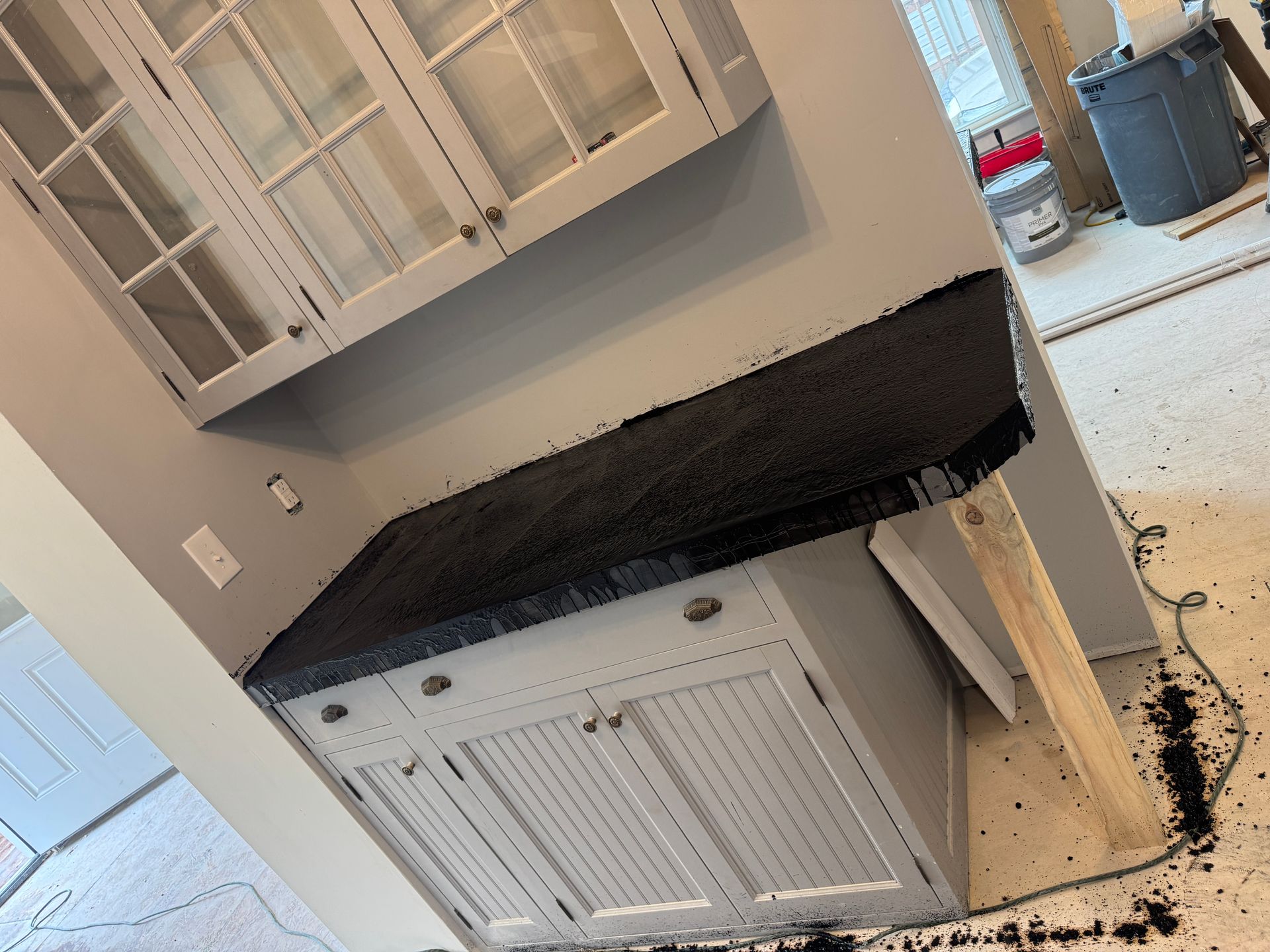 Gray kitchen cabinets with a black countertop.