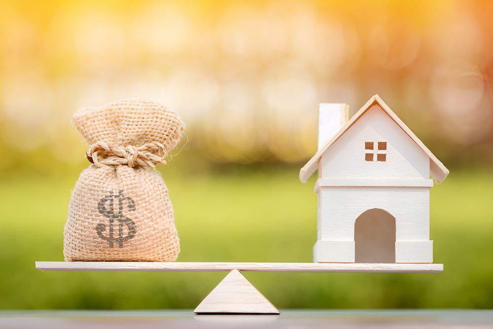 A Scale With A House And A Bag Of Money On It — Christies Accountants & Advisors In Dubbo, NSW
