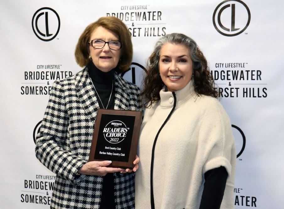 Two women posing with an award plaque at a Bridgewater, Somerset Hills event backdrop.