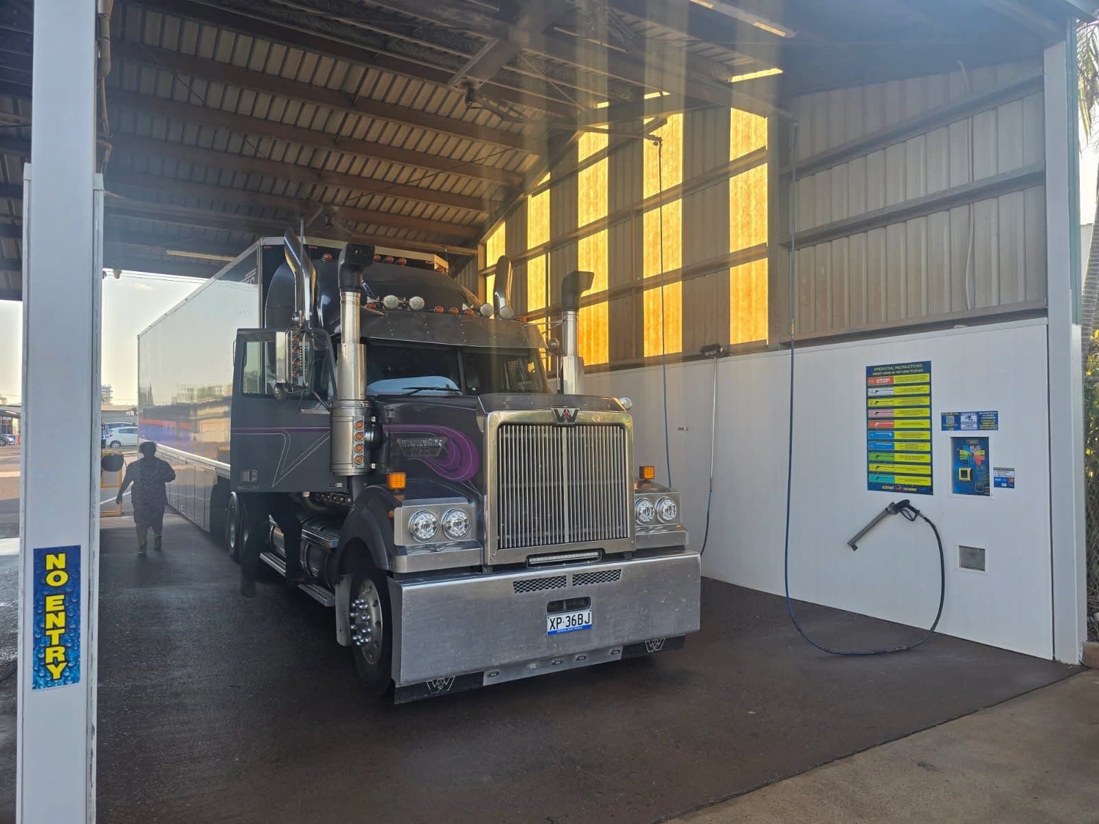 Semi-truck Being Washed in a Bay With a Person Walking Towards It — Ezyas Car Wash NT in Yarrawonga, NT