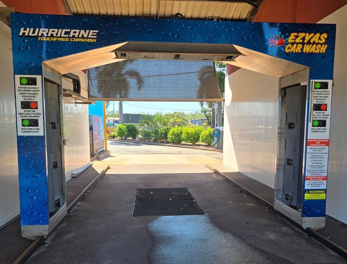 Empty car wash bay with blue and white equipment, open to sunlight outside. — Ezyas Car Wash NT in Yarrawonga, NT