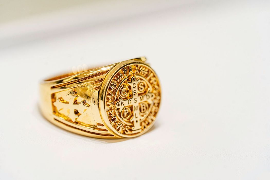 Anello con sigillo in oro con stemma circolare inciso su sfondo bianco.