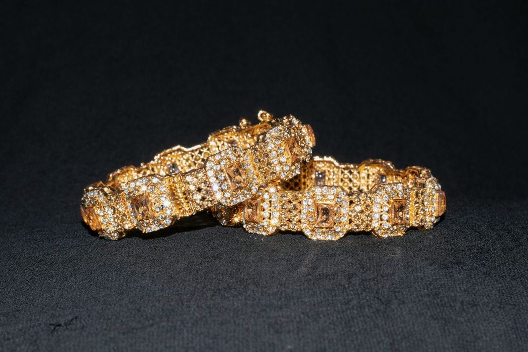 Anelli tempestati d'oro e diamanti impilati su una superficie nera