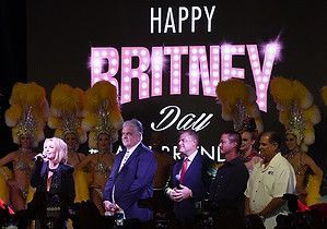 Britney Spears on stage with officials, banner reads