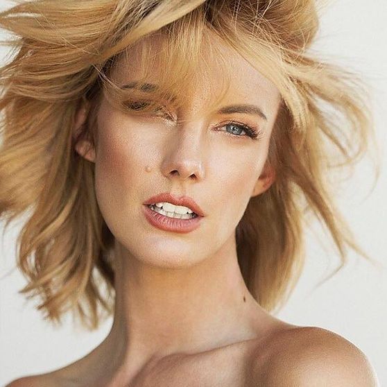 Blonde woman with light skin, slightly open mouth, looking towards camera.
