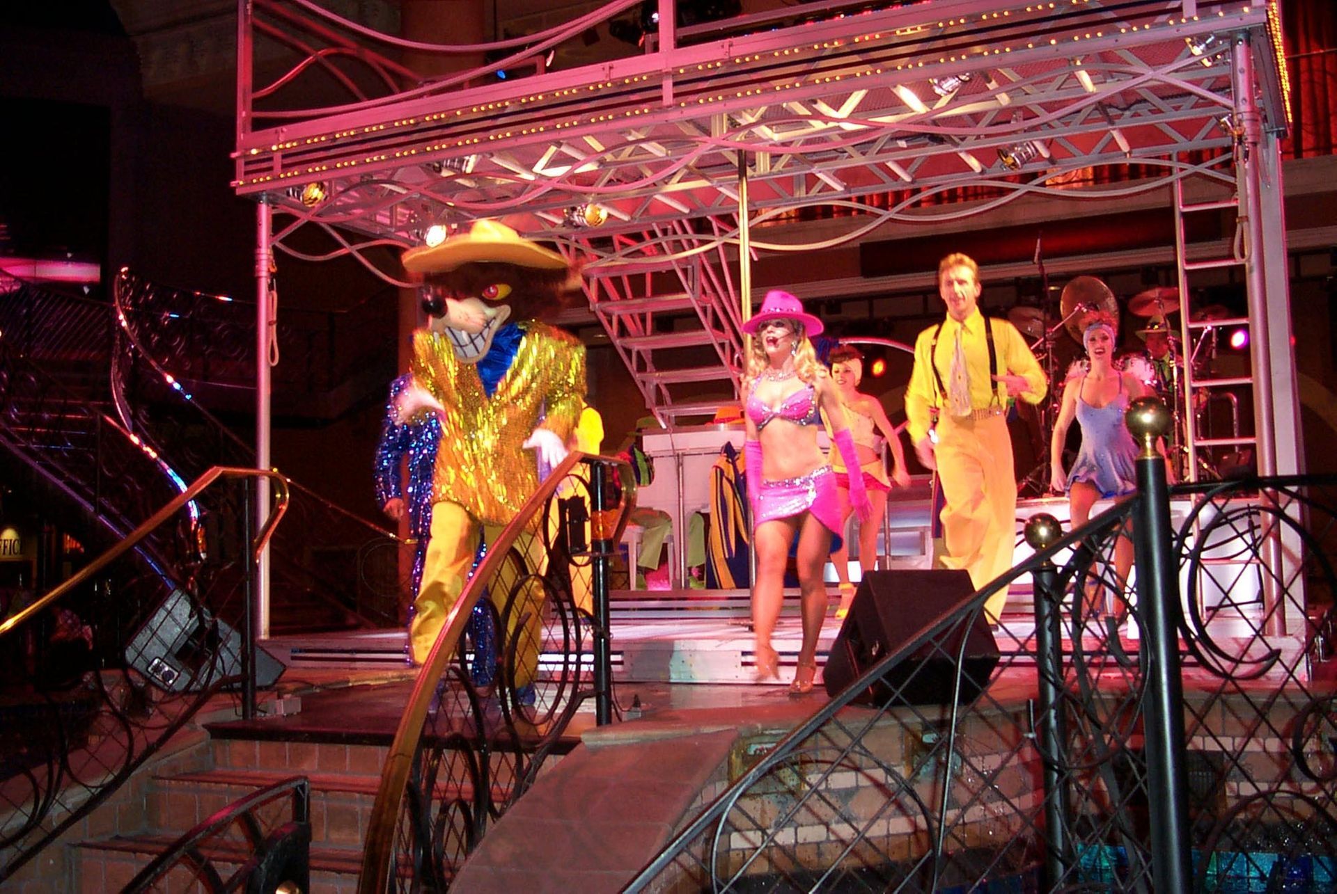 Performers in colorful costumes on a stage with lights.