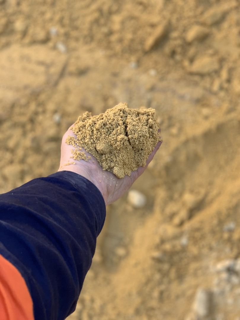 A Person Is Holding A Pile Of Sand In Their Hand — Serious About Landscape Supplies In West Gosford, NSW