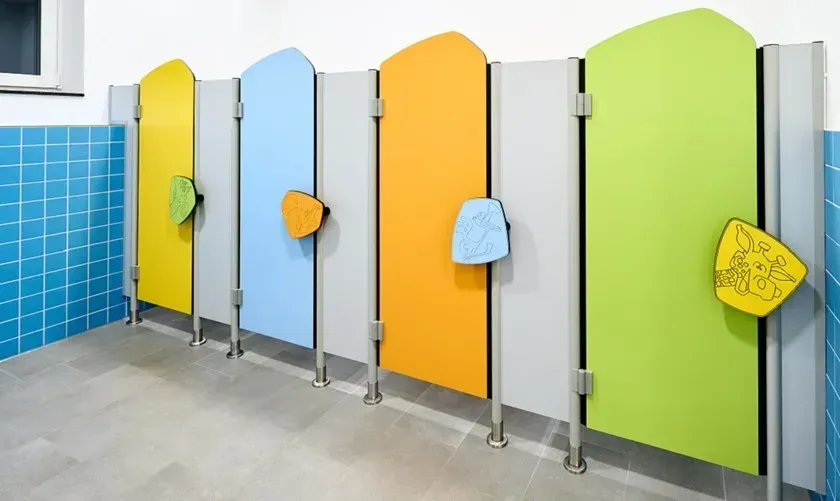 Colorful child-sized bathroom stalls with yellow, blue, and green doors.