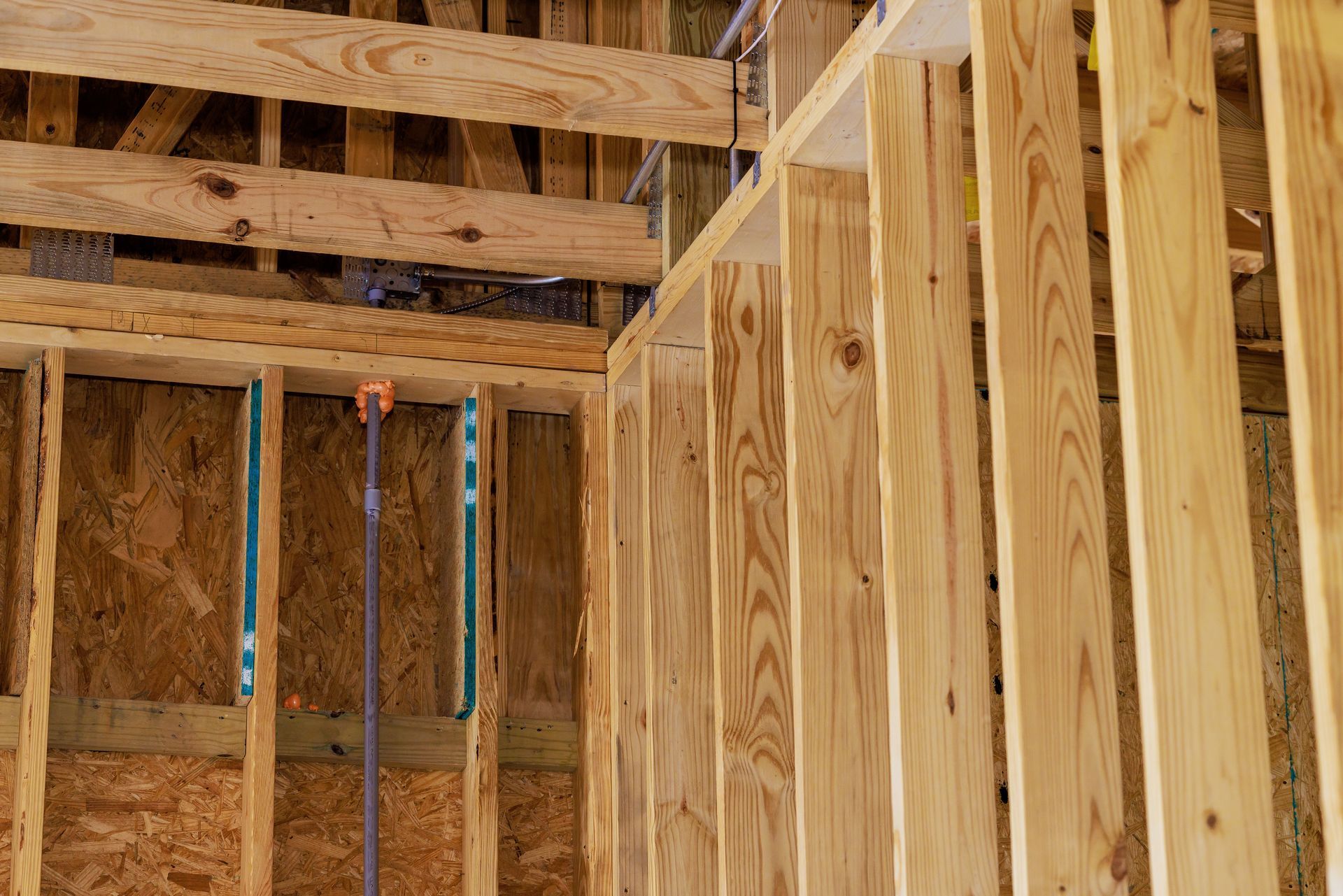 Charpente intérieure d'une maison en construction avec montants et chevrons en bois apparents