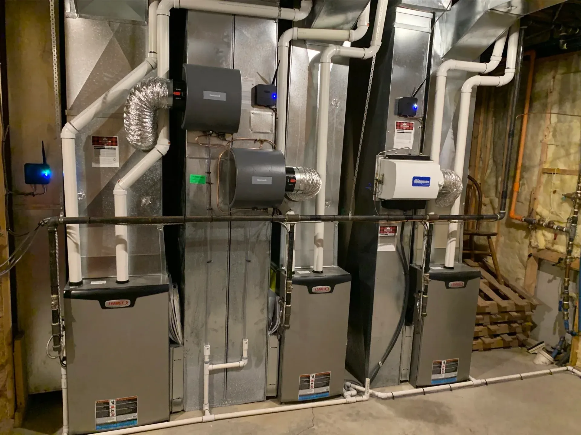 Industrial air filtration system with ductwork against an orange wall.