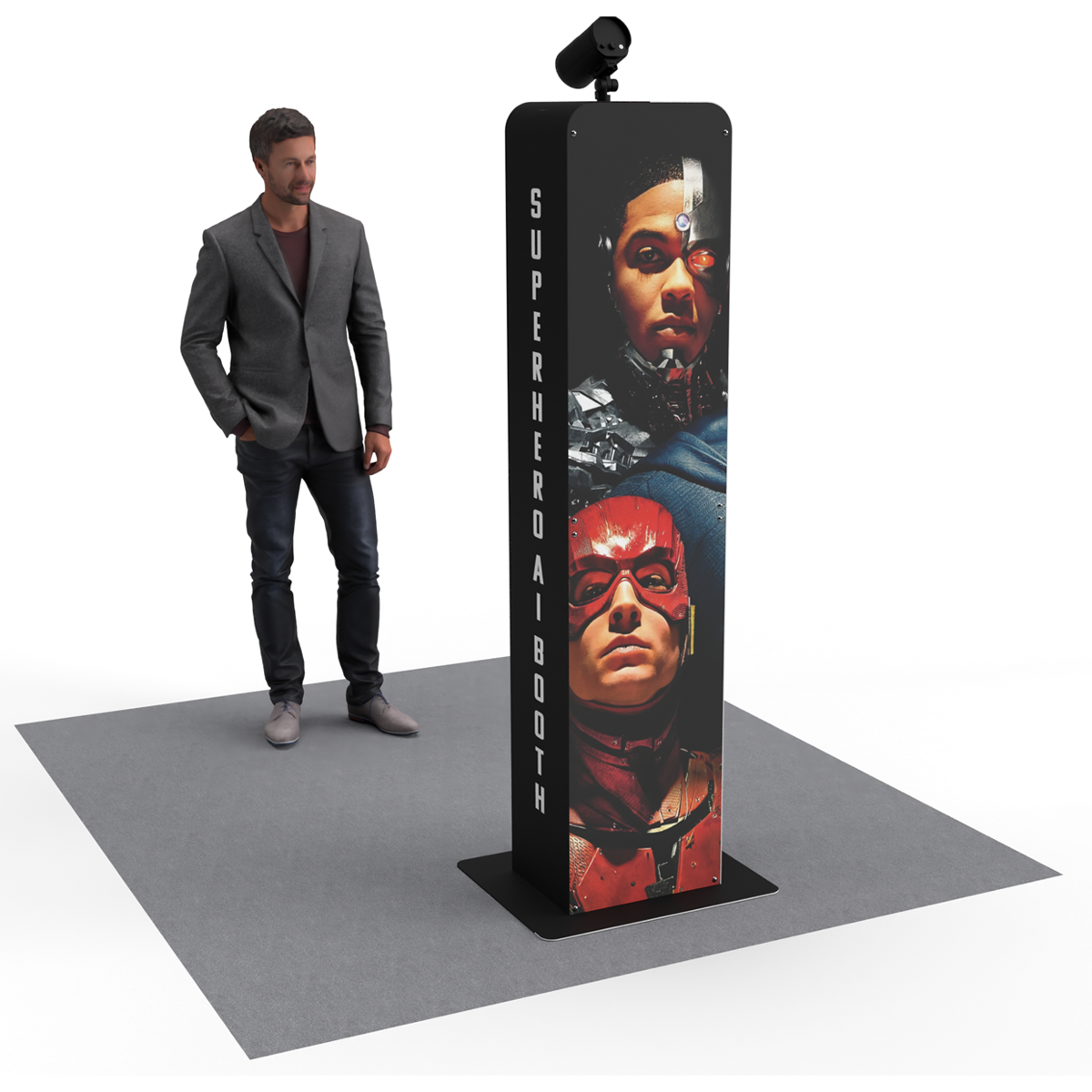 A vertical superhero-themed photo booth tower with an attached camera stands on a gray mat next to a person in a suit.
