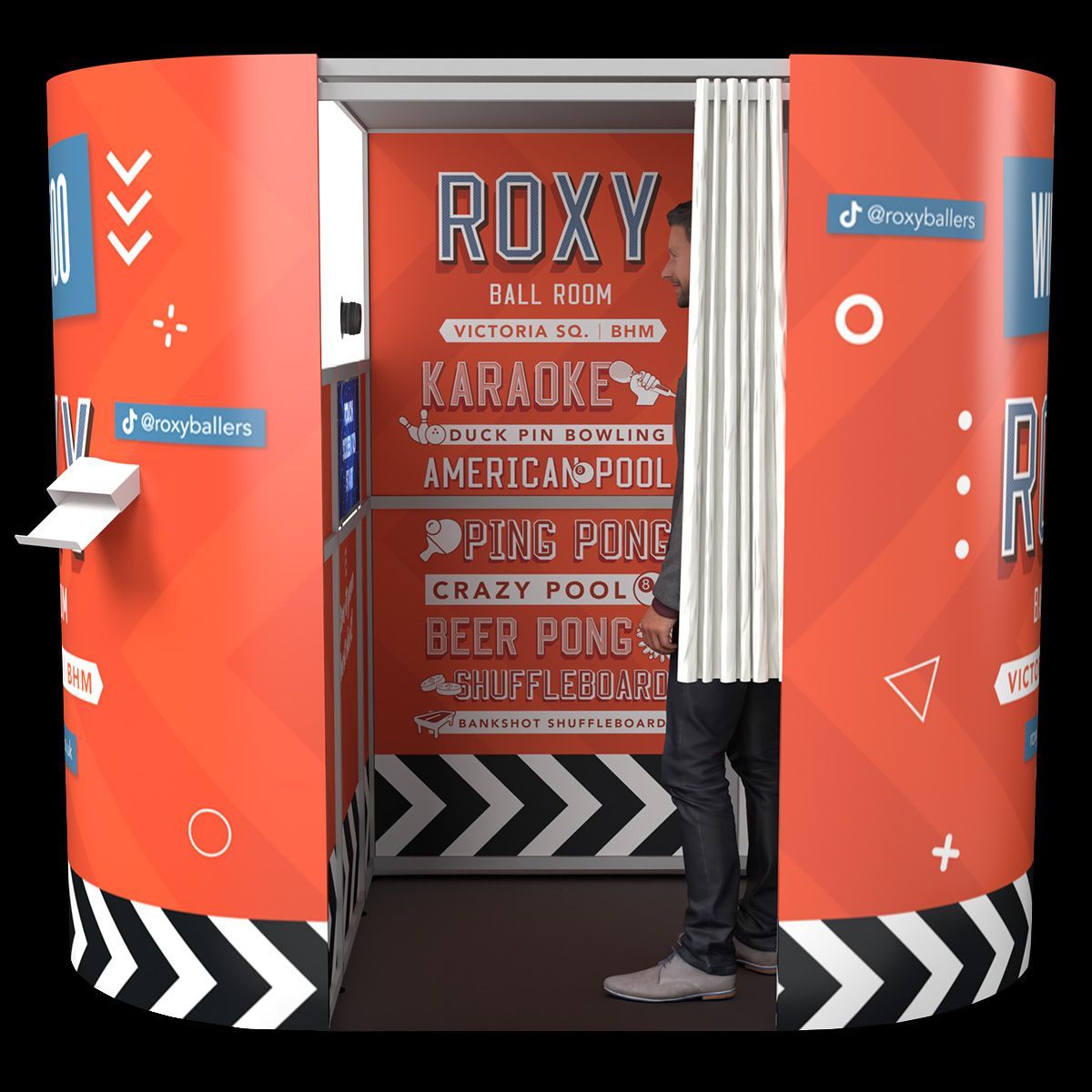 A red, cylindrical photo booth branded for Roxy Ball Room, with a person standing inside near a white curtain.