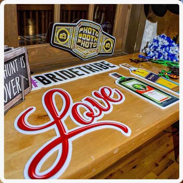 A table covered with various photo booth props, including signs reading 